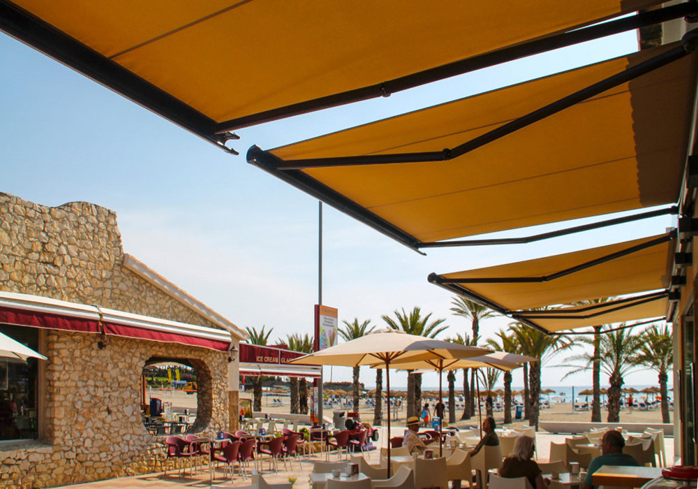 Arabischer Strandflair mit Bestuhlung vor Cafe oder Restaurant mit 4 gelben Markisen