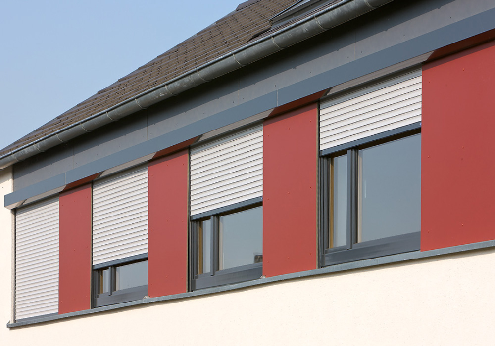 Vorbau-Rollladen Pento P an roter Häuserfassade